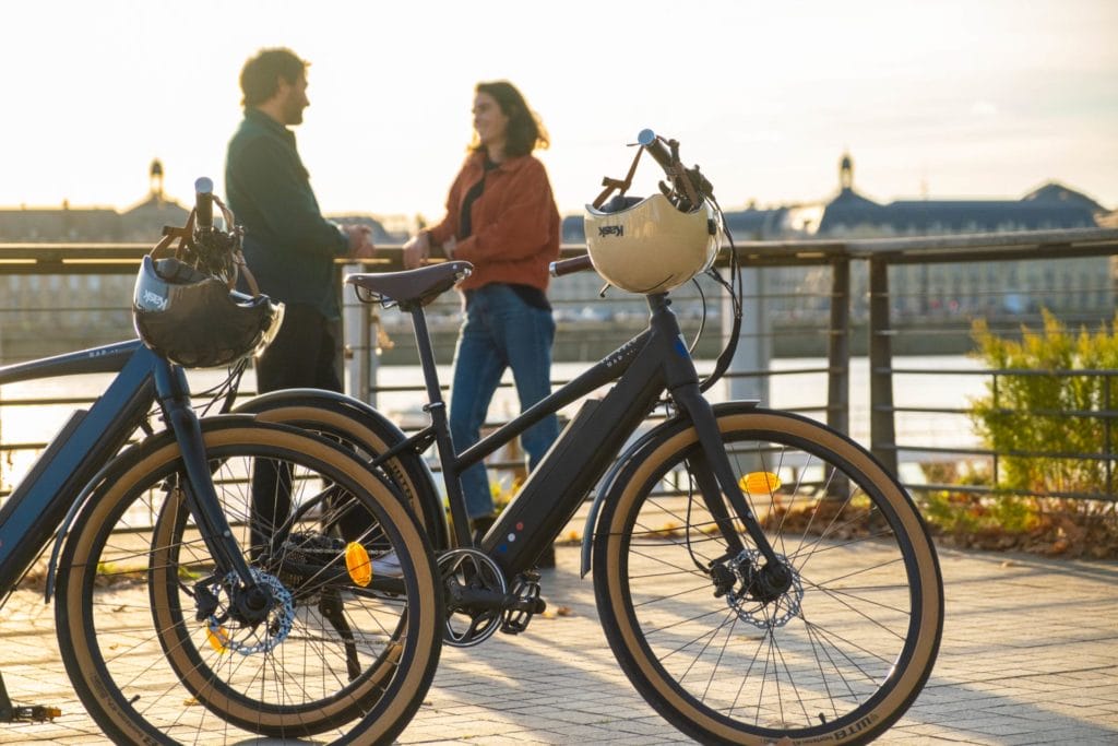 Deux vélos, personnes discutant au coucher de soleil.