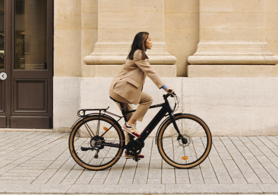 Femme cycliste en ville élégante.