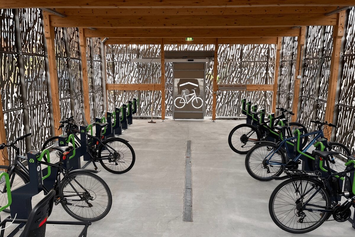 Abri à vélos moderne avec de nombreuses stations de parking sécurisées Bikeep alignées et prêtes à l'emploi.